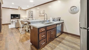 Una cocina con gabinetes de madera, un lavamanos y un lavavajillas empotrado.