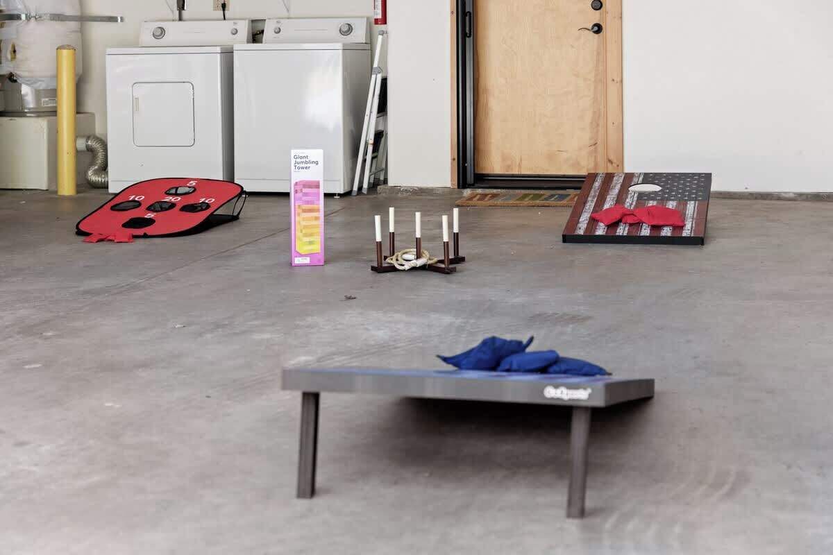 Una habitación con una mesa, un objeto rojo, un letrero y una puerta.