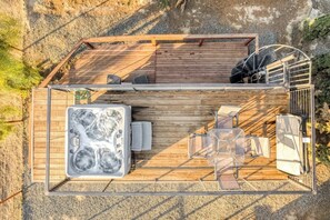 A wooden deck with a hot tub, seating area, and a spiral staircase. - Tiny Cargo Home, Farm Experience with Rooftop Views (Tulare)