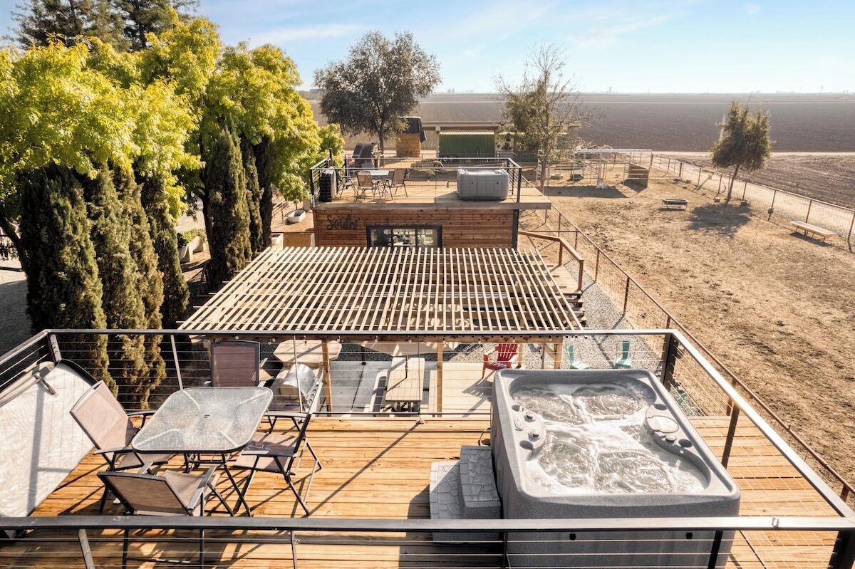 Une terrasse sur le toit dotée d’un jacuzzi, d’un espace salon et offrant une vue sur le paysage environnant.