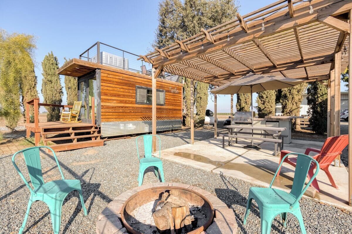 Une cabane en bois dotée d’une terrasse, d’un espace salon extérieur et d’un foyer.