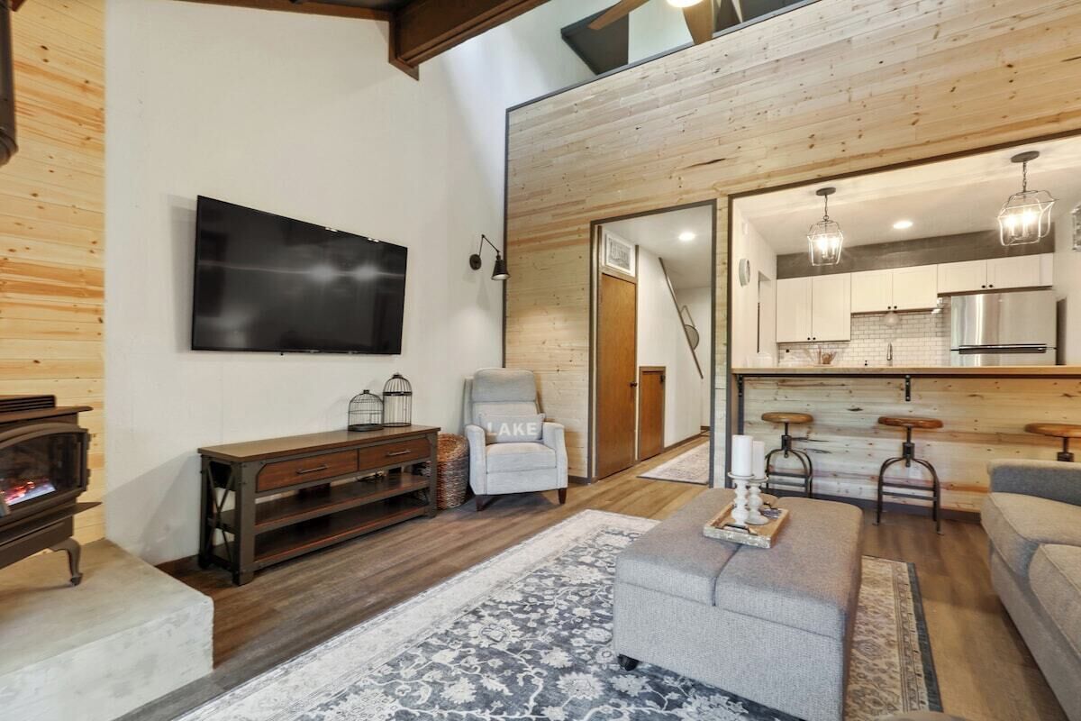 Een moderne woonkamer met een open haard, een televisie en een zithoek.