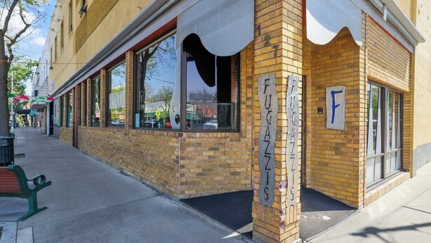A building with a brick facade, large windows, and a sign with the letter 'F'. - Midtown Loft 301 on Main St DT Visalia (Visalia)