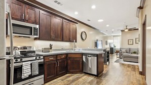 A modern kitchen with dark wood cabinets, stainless steel appliances, and a central island. - Midtown Loft 301 on Main St DT Visalia (Visalia)