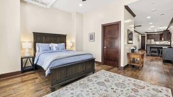 Un dormitorio con una cama grande, lámparas de noche, un cabecero de madera y un tapete floral.