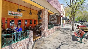 A restaurant with outdoor seating, a patio area, and a street view with parked cars. - Midtown Loft 301 on Main St DT Visalia (Visalia)