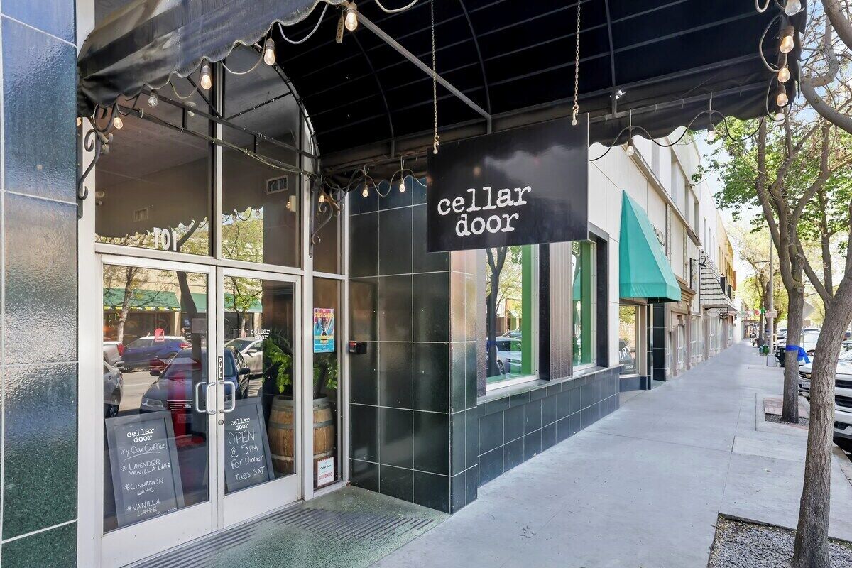 Une devanture de magasin avec une enseigne indiquant « cave à vin » et un panneau affichant le menu à l’extérieur.