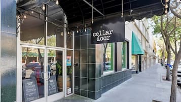 Un escaparate con un cartel que dice 'cellar door' y una pizarra con el menú en el exterior.