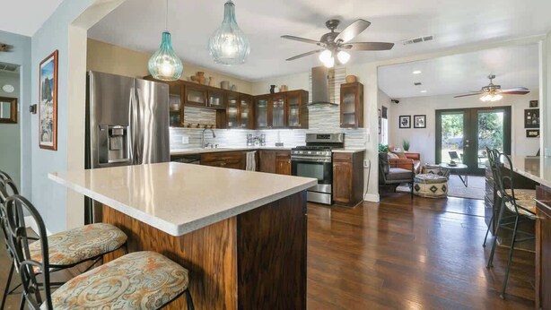 A spacious kitchen with wooden cabinets, a central island, and a dining area with bar stools.