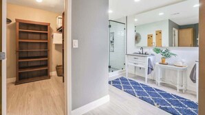 A modern bathroom with a glass shower, a white sink, and a mirror above it.