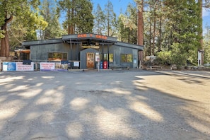 A rustic cabin-style building labeled 'PUB N GRUB' with a dirt ground in front, surrounded by tall trees.