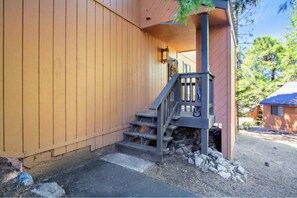 A wooden exterior with a stone foundation, a wooden staircase, and a small porch area. - Parker's Peak Cabin w BBQ Grill & Community Pool (Shaver Lake)