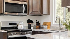 A modern kitchen with stainless steel appliances, a built-in oven, and a microwave.