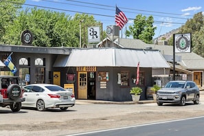 A storefront with a sign for 'DRY GOODS' and a flag. - Tiny River House w River Frontage (Three River)