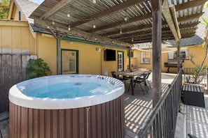 A hot tub under a wooden pergola on a patio with a table and chairs. - Downtown Retreat w/ Pool & Spa, Near National Parks (Visalia)