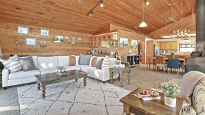 A spacious living room with a white sofa, wooden coffee table, and a fireplace.