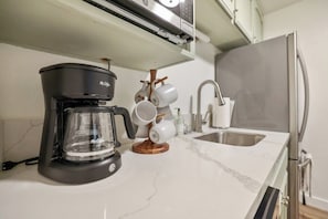 A kitchen with a coffee maker, a sink, and a marble countertop. - Two Bears Basecamp | Views, Trails, Flat Parking (Shaver Lake)