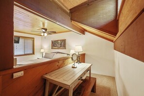 A bedroom with a wooden bed, bedside lamps, a mirror, a window with blinds, and a ceiling fan. - Two Bears Basecamp | Views, Trails, Flat Parking (Shaver Lake)