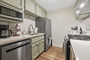 A kitchen with a stainless steel refrigerator, a microwave, a coffee maker, and a gas stove. - Two Bears Basecamp | Views, Trails, Flat Parking (Shaver Lake)