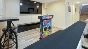 Ein Zimmer mit einem Mario-Spiel, einem schwarzen Tisch und einer Bank.