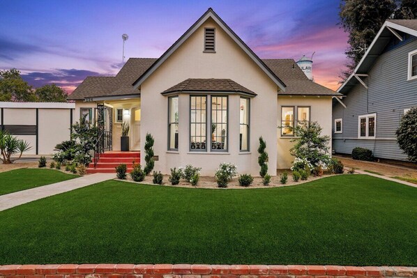 A two-story house with a bay window, a front porch, and a well-maintained lawn.