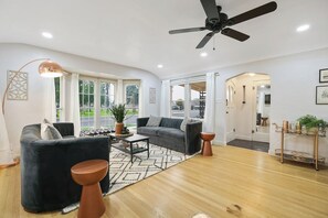 A modern living room with a sofa, coffee table, and a ceiling fan.