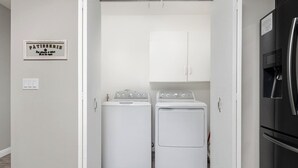 A laundry room with two white washing machines and a cabinet above them. - Visalia Luxe CA: 3BR w/ Private Pool, BBQ, & Patio (Visalia)