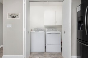 A laundry room with two white washing machines and a cabinet above them. - Visalia Luxe CA: 3BR w/ Private Pool, BBQ, & Patio (Visalia)