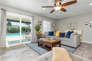 A living room with a sofa, coffee table, and a ceiling fan.