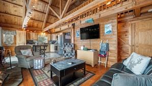 A wooden cabin interior with a living room, kitchen, and dining area. - A Lookout at 'The Overlook' - Fall in love with this Rangeley cabin! (Rangeley)