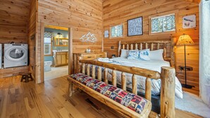 A wooden cabin interior with a bunk bed, a bench, a washing machine, a sink, and a window with a view. - A Lookout at 'The Overlook' - Fall in love with this Rangeley cabin! (Rangeley)