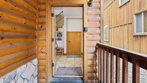 A wooden cabin with a stone foundation, a wooden staircase leading to a door, and a small outdoor area with a bench. - Mins to Lake, enjoy Shaver at PJ's Retreat! (Shaver Lake)