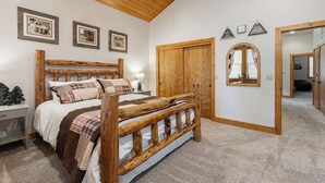 A bedroom with a wooden bed, a nightstand, a wardrobe, and a mirror. - Mins to Lake, enjoy Shaver at PJ's Retreat! (Shaver Lake)