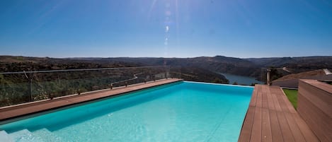 Una piscina al aire libre de temporada, sombrillas