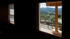 Una habitación con ventana que da a un paisaje montañoso.