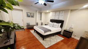 A bedroom with a bed, bedside tables, a ceiling fan, and a door.