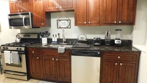 A kitchen with wooden cabinets, stainless steel appliances, a sink, and a dishwasher.