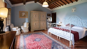 Une chambre à coucher avec un lit, une chaise, une armoire et une lampe suspendue.