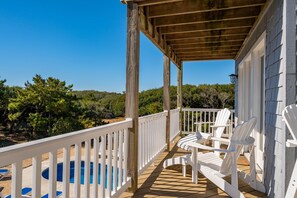 A wooden deck with white railings, a pool, and Adirondack chairs. - Here & Now: Semi-Oceanfront, private pool, hot tub, steps to the beach, two living areas. (Southern Shores)