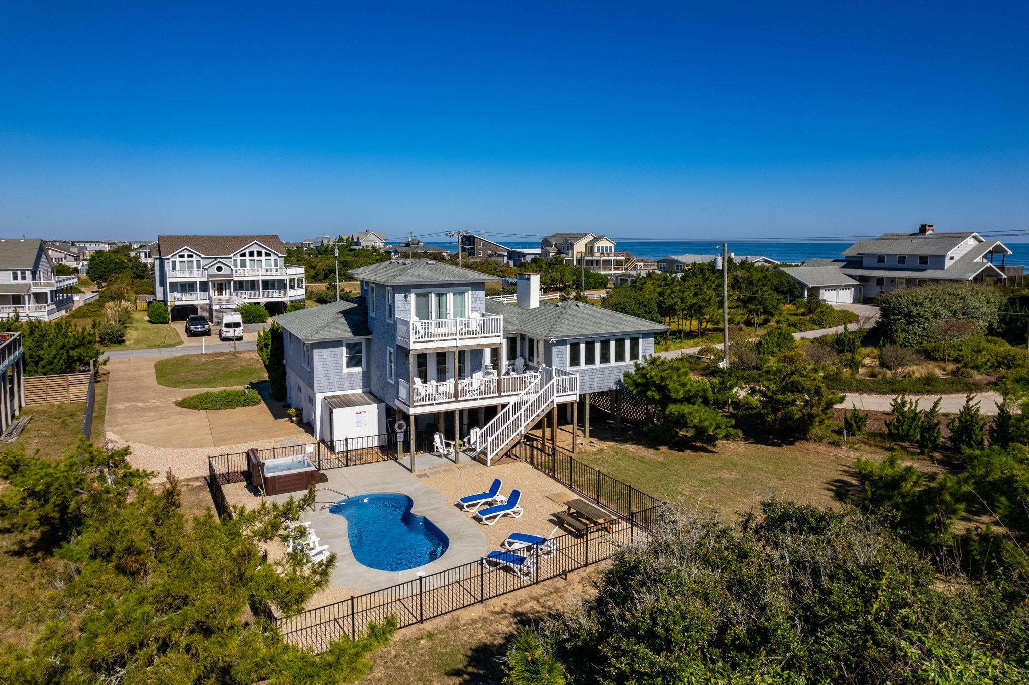 A large two-story house with a swimming pool and a deck area.