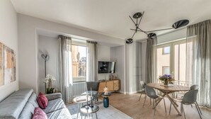 Un salon moderne avec un canapé, une table à manger et un téléviseur.