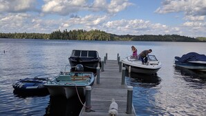 Une jetée en bois s’étendant sur une étendue d’eau calme, avec des bateaux amarrés à son extrémité.