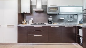 Una cocina moderna con armarios de madera oscura, electrodomésticos de acero inoxidable y un horno empotrado.