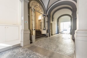 A hallway with a tiled floor, white walls, and arched doorways. - Matteotti Bilo in Firenze (Florence)