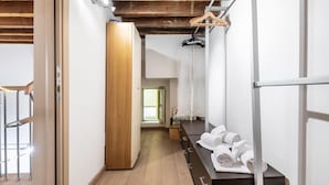 Un baño moderno con suelo de madera, una puerta de madera, un perchero y un espejo.