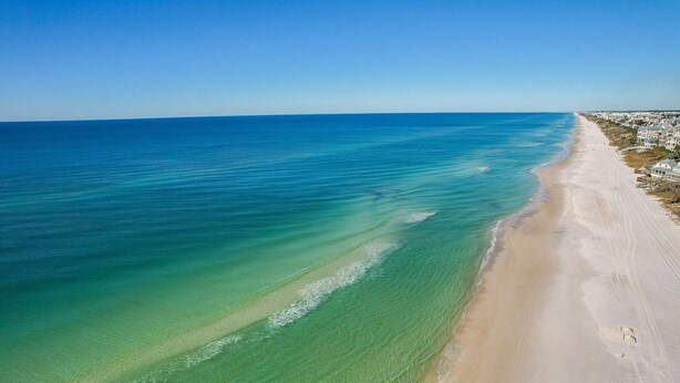 A beach with clear water and a sandy shore. - Surfer Dog 4 Bedroom Home by RedAwning (Panama City Beach)