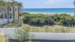 A coastal view with a building, beach, and clear sky. - Surfer Dog 4 Bedroom Home by RedAwning (Panama City Beach)