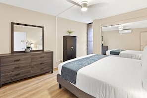 A bedroom with a bed, dresser, mirror, and ceiling fan. - Wake to Haleakalā Sunrises and Endless Ocean Views (Wailuku)