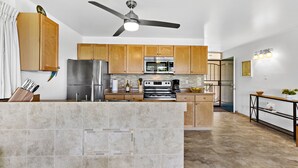 A modern kitchen with wooden cabinets, stainless steel appliances, and a central island.