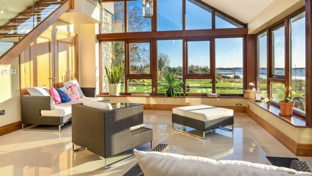 Ein geräumiges Zimmer mit großem Fenster, einem Bett, einer Couch und einem Esstisch.